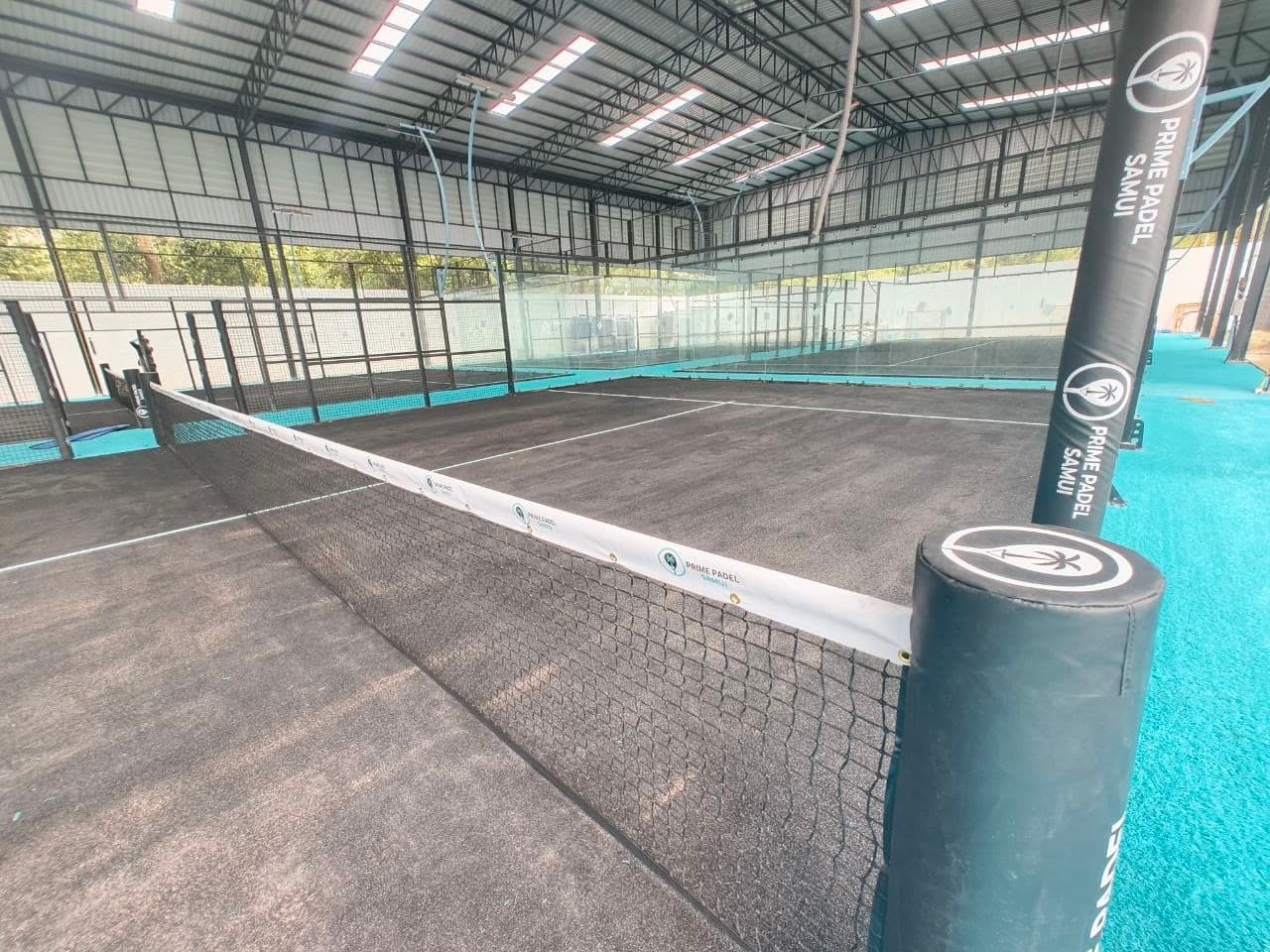 Covered super-panoramic padel courts inside the glass-walled hall